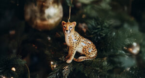 A Cheetah ornament hanging from a Christmas tree.