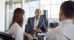 A professional overviewing trust investment management software with clients.